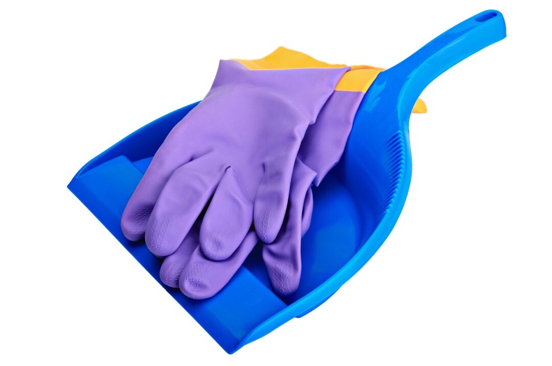 A blue cleaning pan with two violet rubber gloves on top on white background